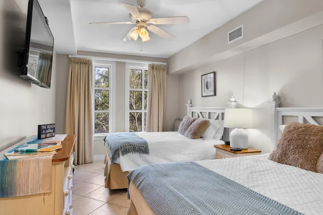 a bedroom with a bed and a flat tv screen on the dresser