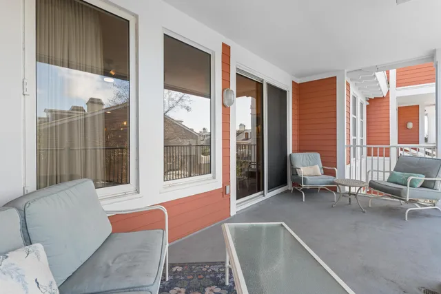 a living room with furniture and large windows