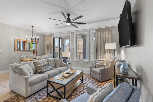 a living room with furniture a ceiling fan and a window