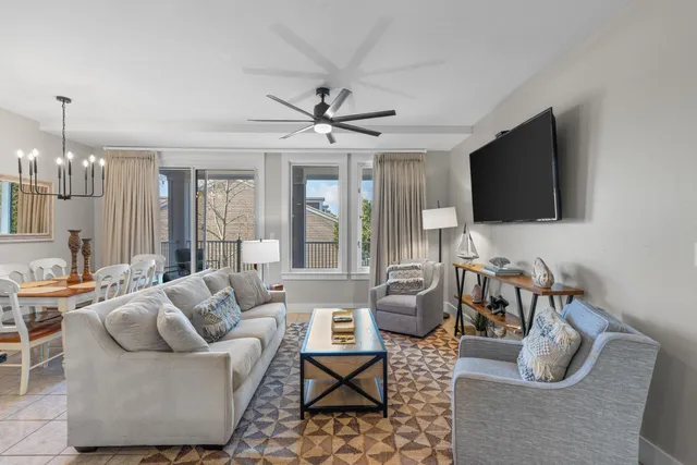 a living room with furniture a flat screen tv and a large window