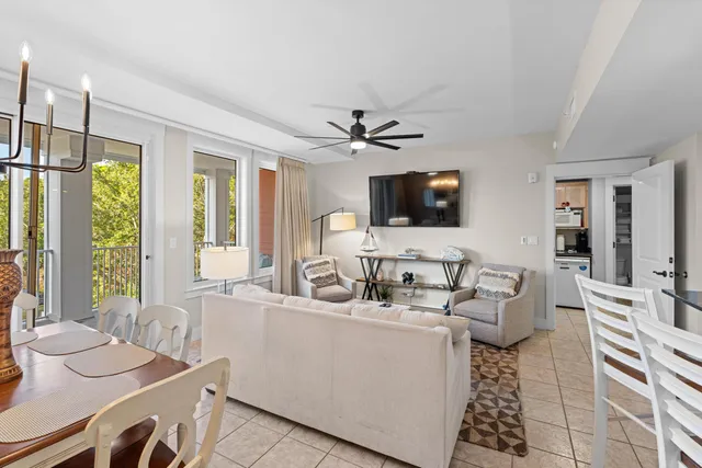 a living room with furniture a flat screen tv and a large window