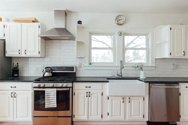 a kitchen with granite countertop a sink cabinets and stainless steel appliances