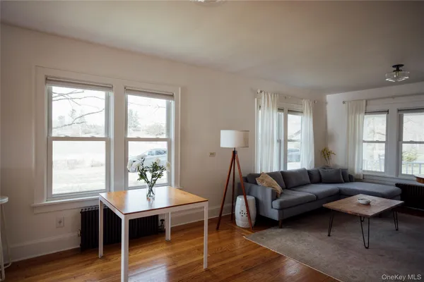 a living room with furniture a wooden floor and a window