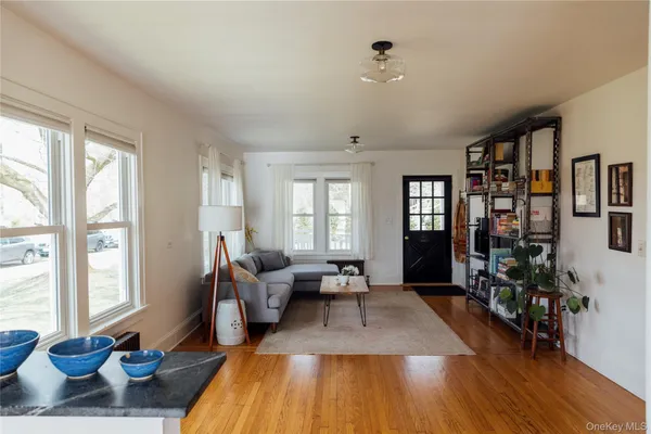 a living room with furniture large window and wooden floor