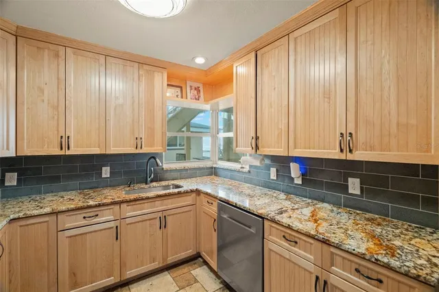 a kitchen with granite countertop cabinets stainless steel appliances and a sink