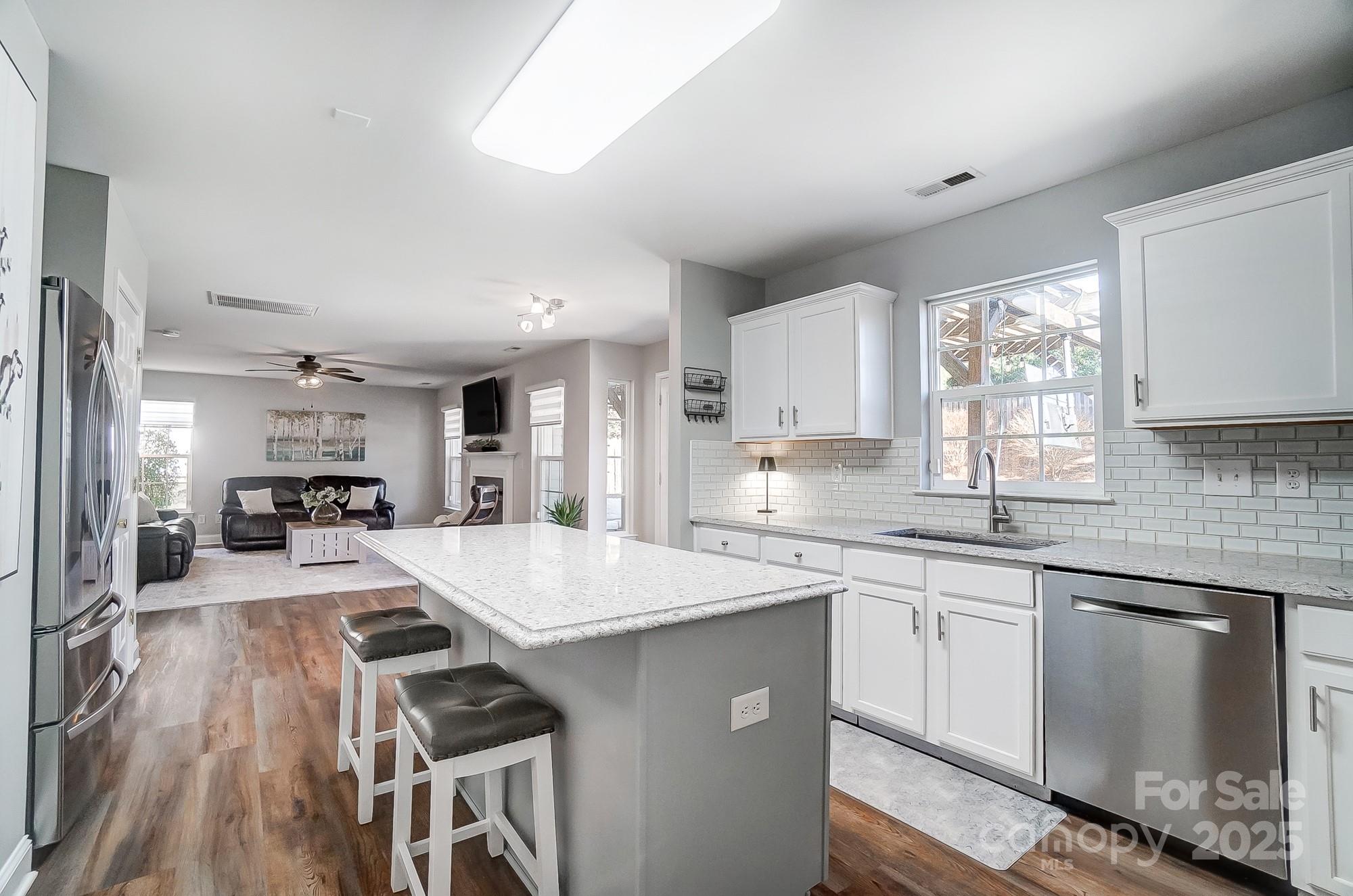 7647 Black Hawk Lane Tega Cay, SC 29708 - Photo 12 of 42 a large kitchen with kitchen island a sink stove and white cabinets