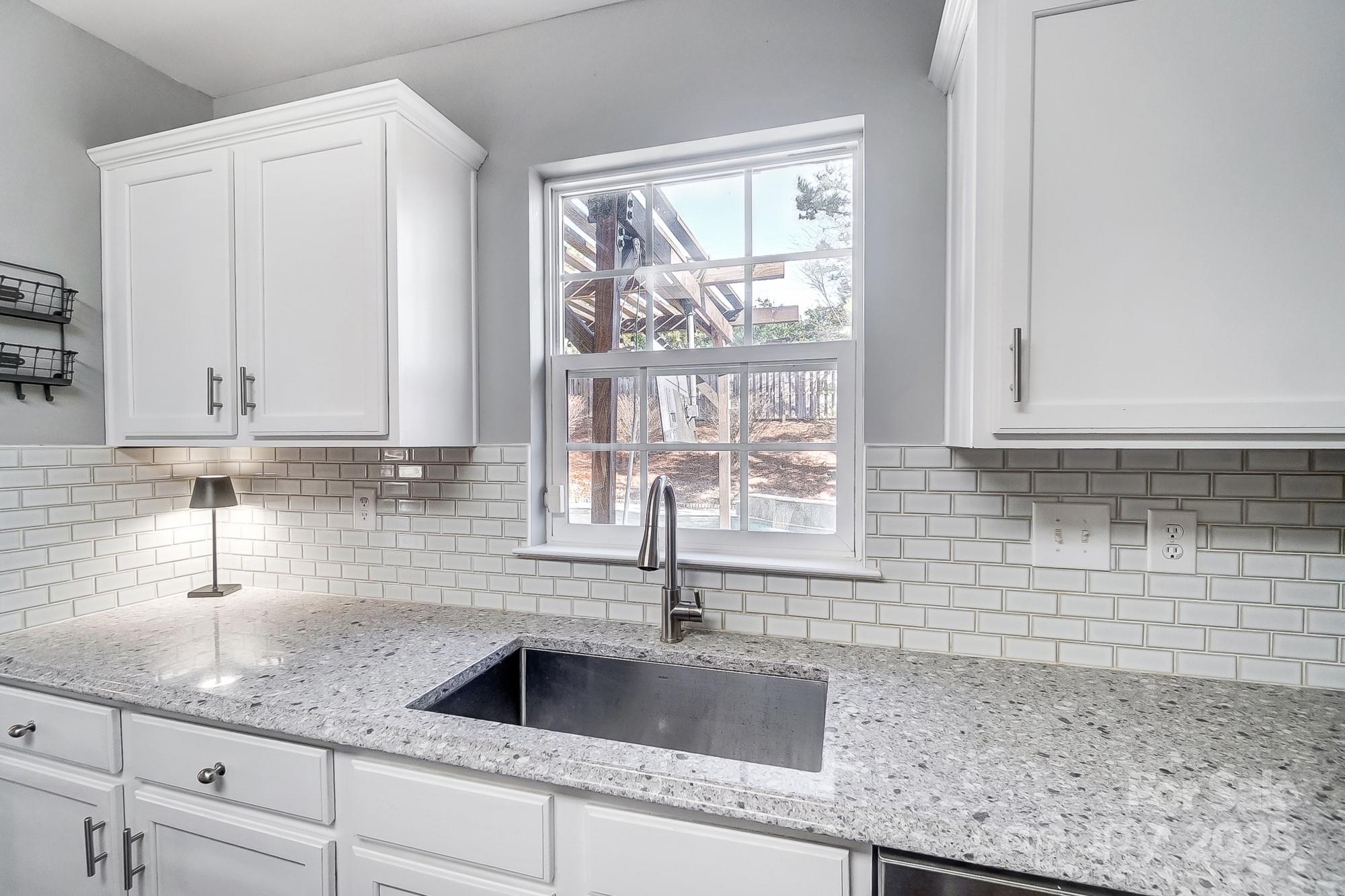 7647 Black Hawk Lane Tega Cay, SC 29708 - Photo 13 of 42 a kitchen with granite countertop a sink a window and cabinets