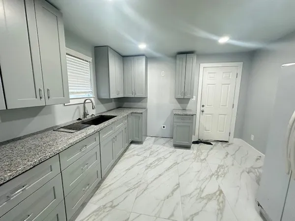 a large kitchen with a stove a sink and a refrigerator