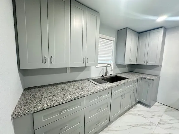 a kitchen with granite countertop cabinets sink and dishwasher