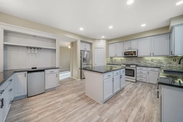 a kitchen with stainless steel appliances granite countertop a stove a sink and a refrigerator