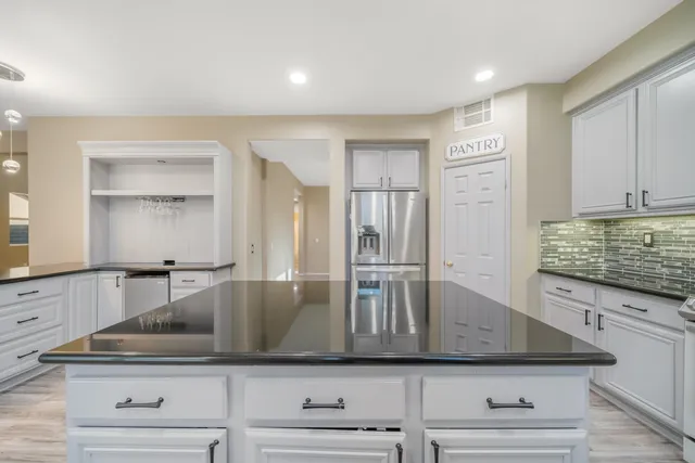 a view with granite countertop a sink and a stove top oven with wooden floor