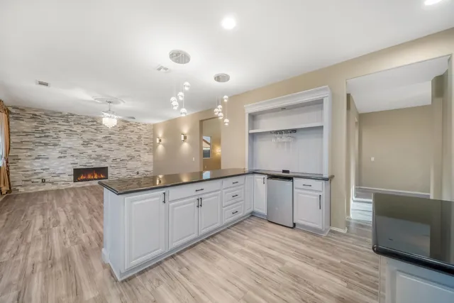 a large kitchen with stainless steel appliances a large counter top a stove and a refrigerator