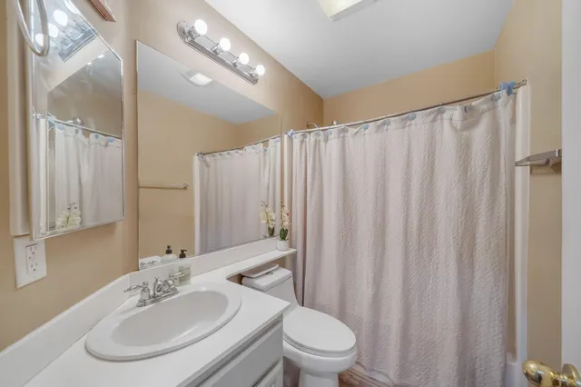 a bathroom with a toilet a sink and a mirror