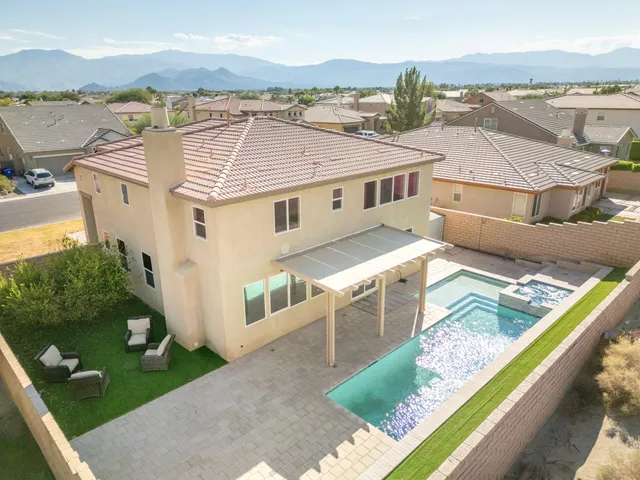 an aerial view of residential houses with outdoor space and ocean view