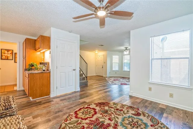 a view of a hallway with wooden floor and a bathroom