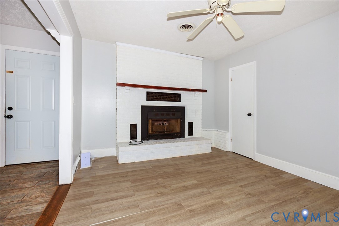 9903 Boze Road Ford, VA 23850 - Photo 14 of 45 a view of an empty room with wooden floor fireplace and a window