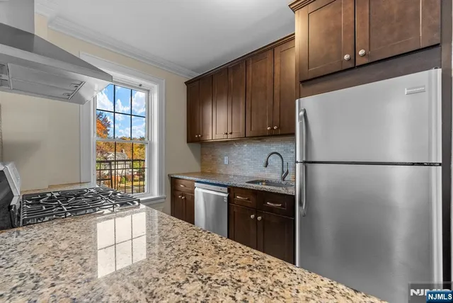 a kitchen with a refrigerator and a stove top oven