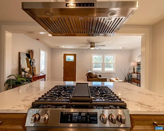 a kitchen with stainless steel appliances kitchen island wooden cabinets a stove a sink and a refrigerator