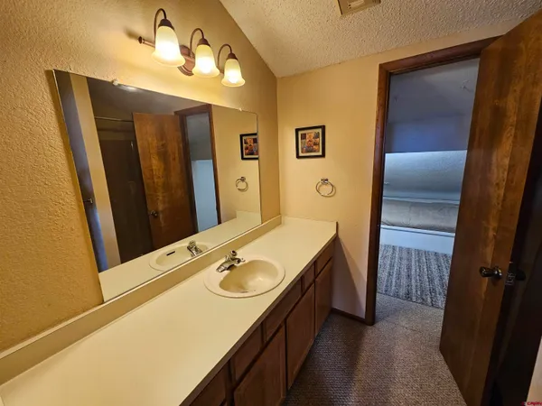 a bathroom with a granite countertop toilet sink and mirror