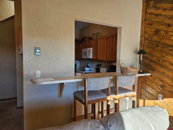 a room with a table chairs and a kitchen view