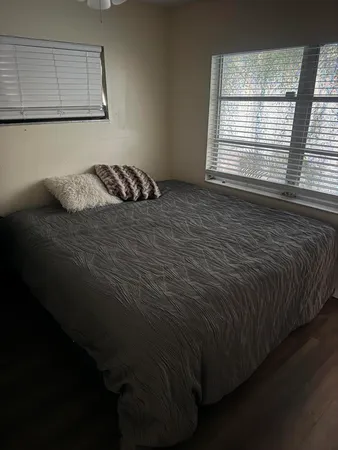 a bed sitting in a bedroom next to a window