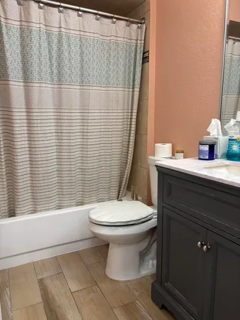 a bathroom with a sink a toilet and shower