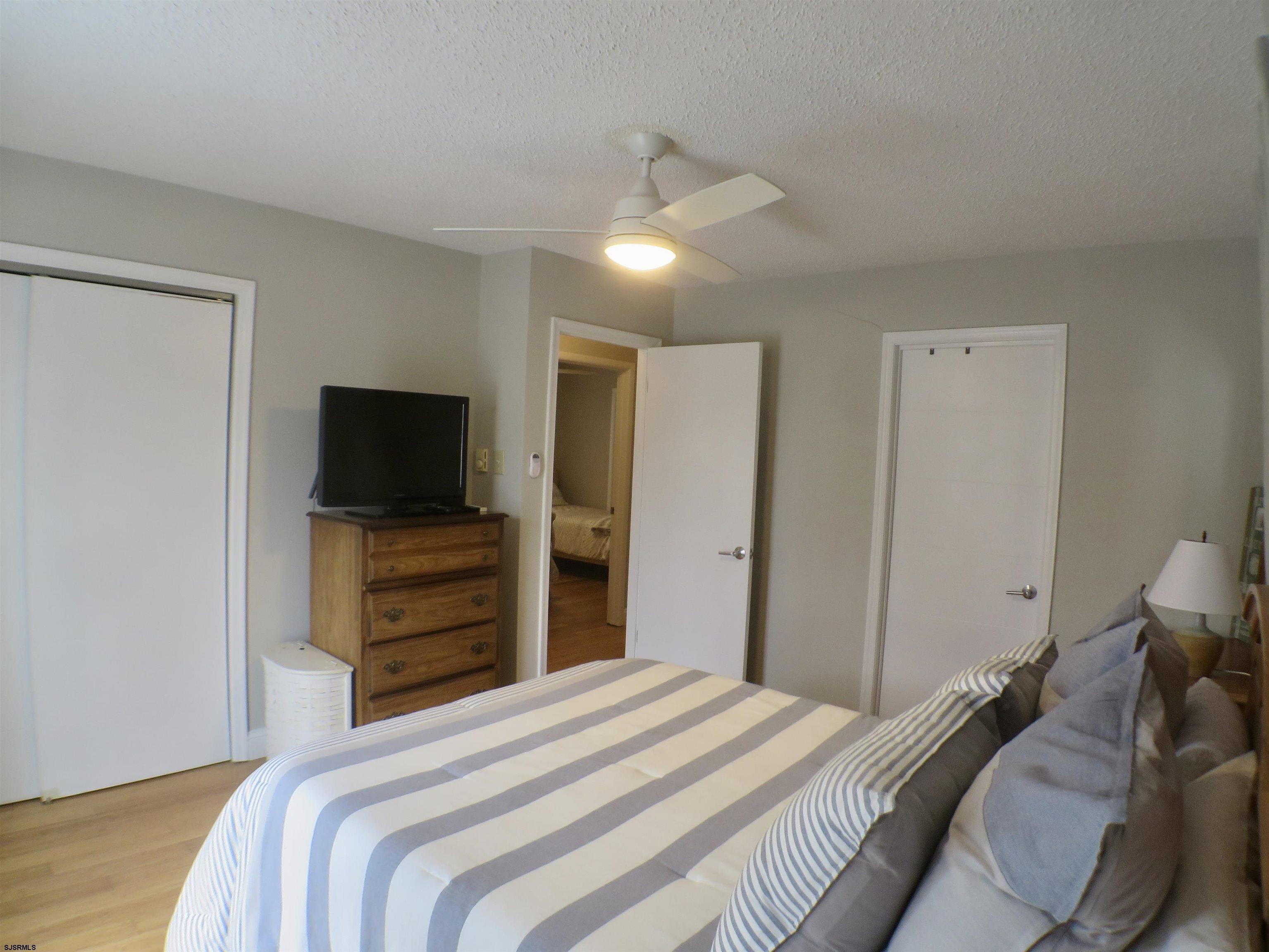 210 Simpson Avenue, Unit 2 Ocean City, NJ 08226 - Photo 11 of 20 a bedroom with a bed and a flat screen tv