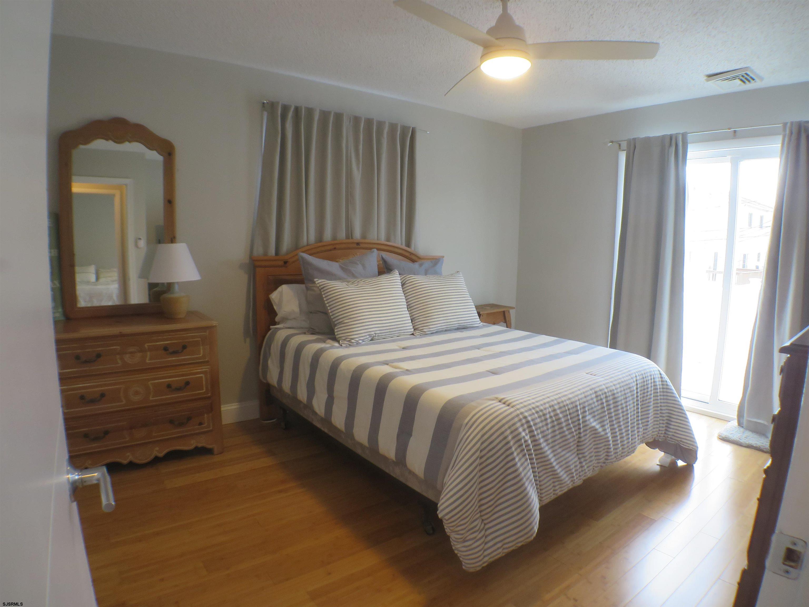 210 Simpson Avenue, Unit 2 Ocean City, NJ 08226 - Photo 13 of 20 a bedroom with a bed and a mirror