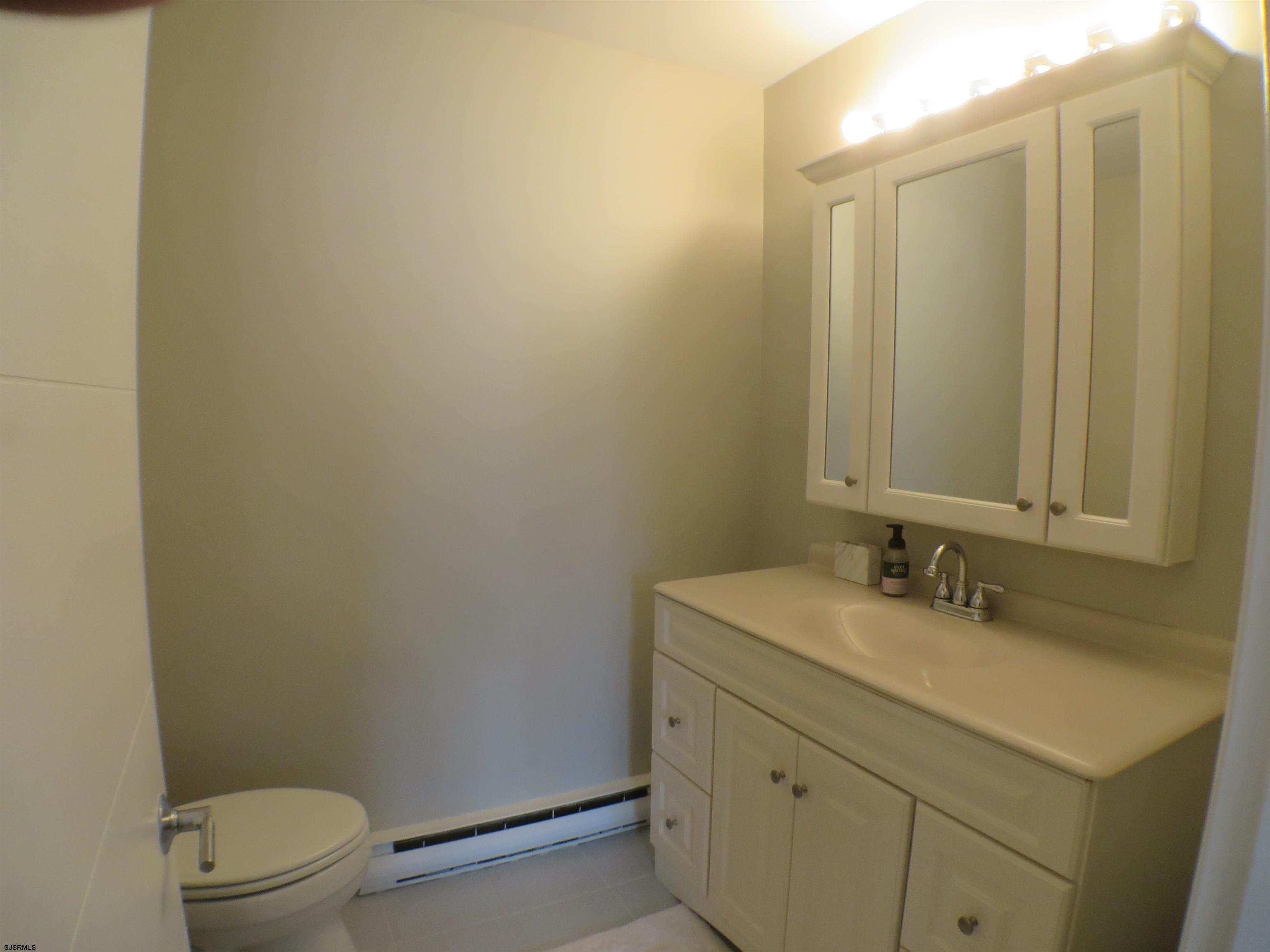 210 Simpson Avenue, Unit 2 Ocean City, NJ 08226 - Photo 14 of 20 a bathroom with a sink a toilet and mirror