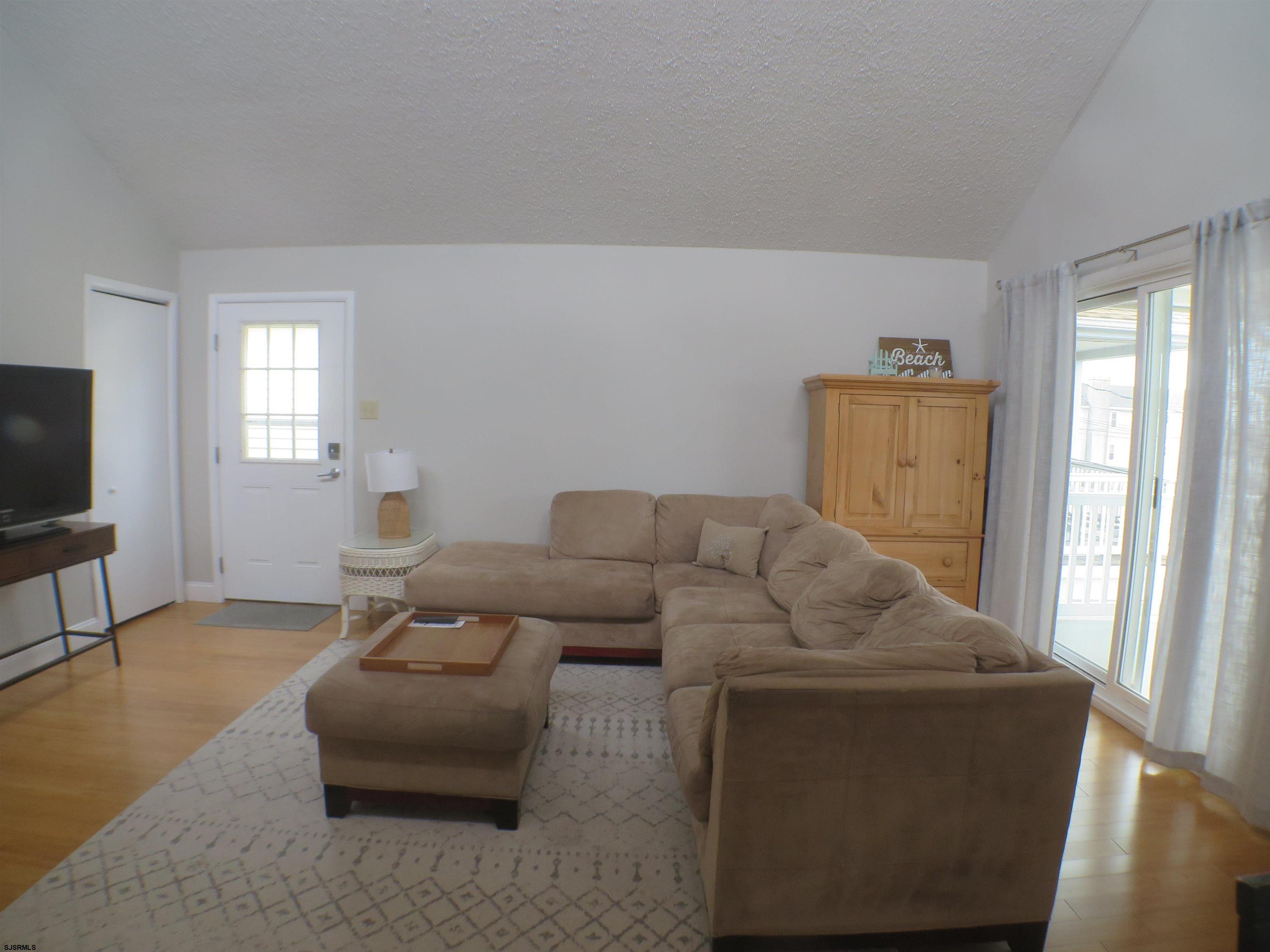 210 Simpson Avenue, Unit 2 Ocean City, NJ 08226 - Photo 4 of 20 a living room with furniture and a flat screen tv