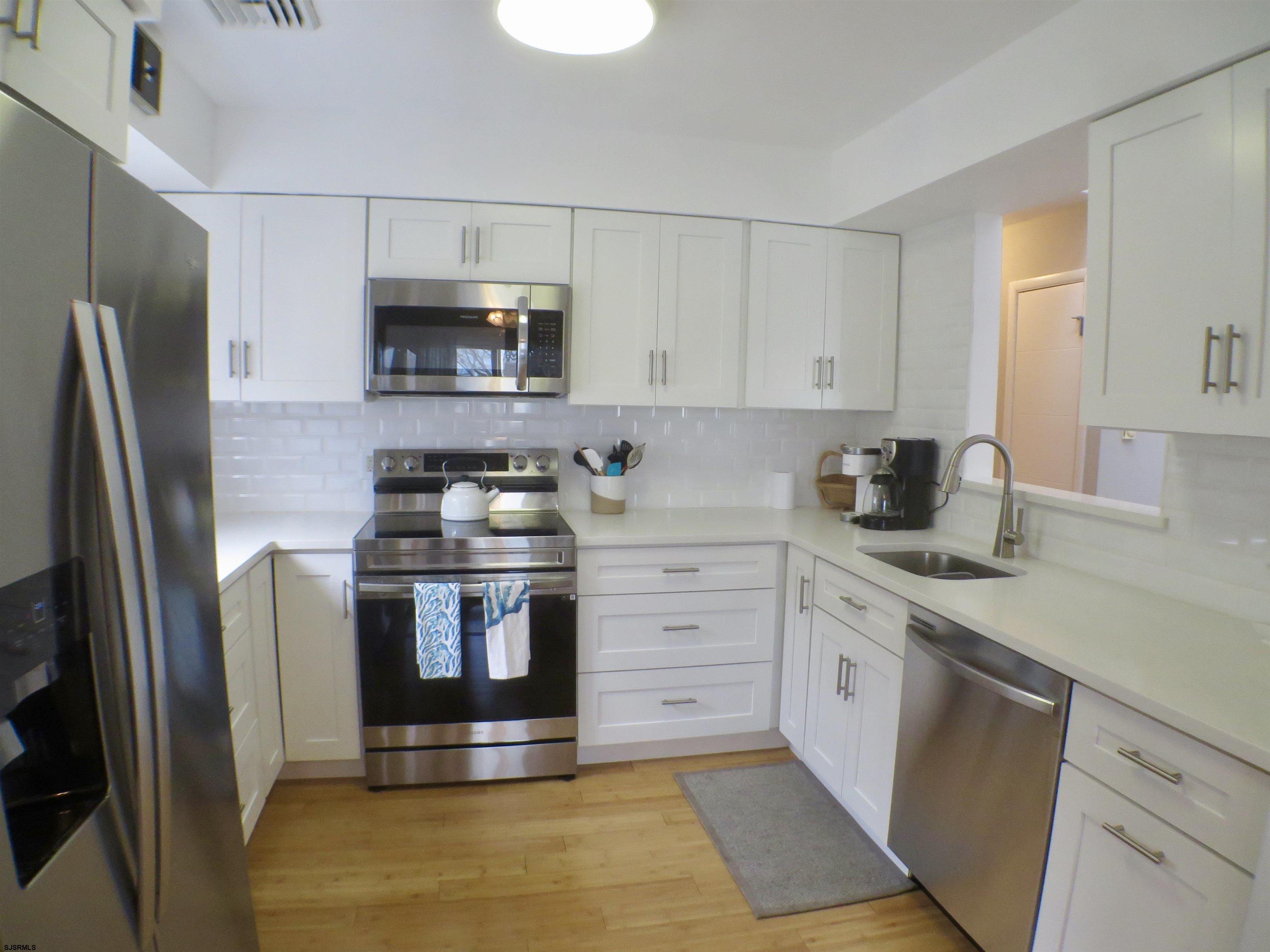 210 Simpson Avenue, Unit 2 Ocean City, NJ 08226 - Photo 9 of 20 a kitchen with stainless steel appliances granite countertop a stove a refrigerator and a sink