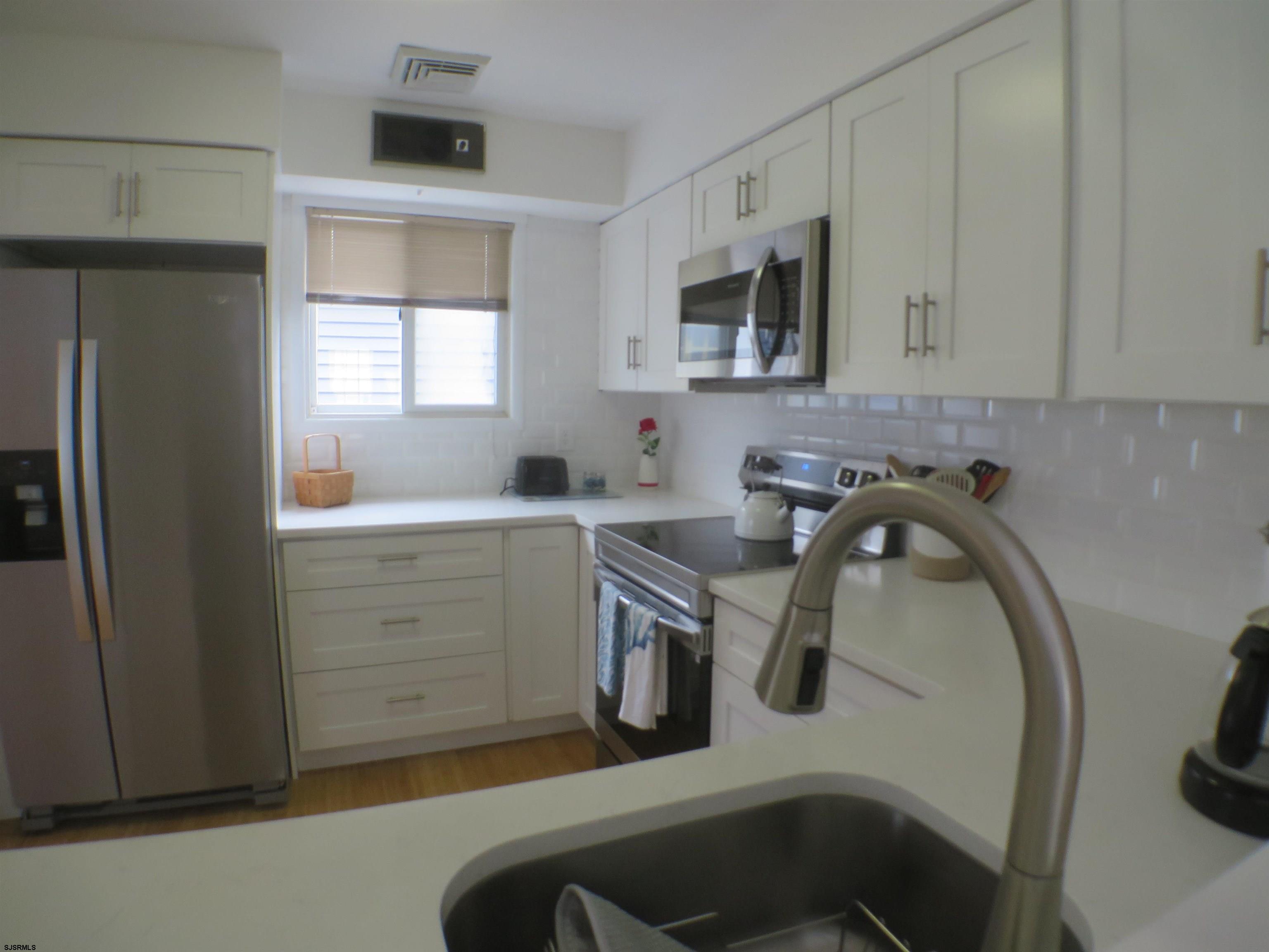 210 Simpson Avenue, Unit 2 Ocean City, NJ 08226 - Photo 10 of 20 a kitchen with a sink a stove and cabinets