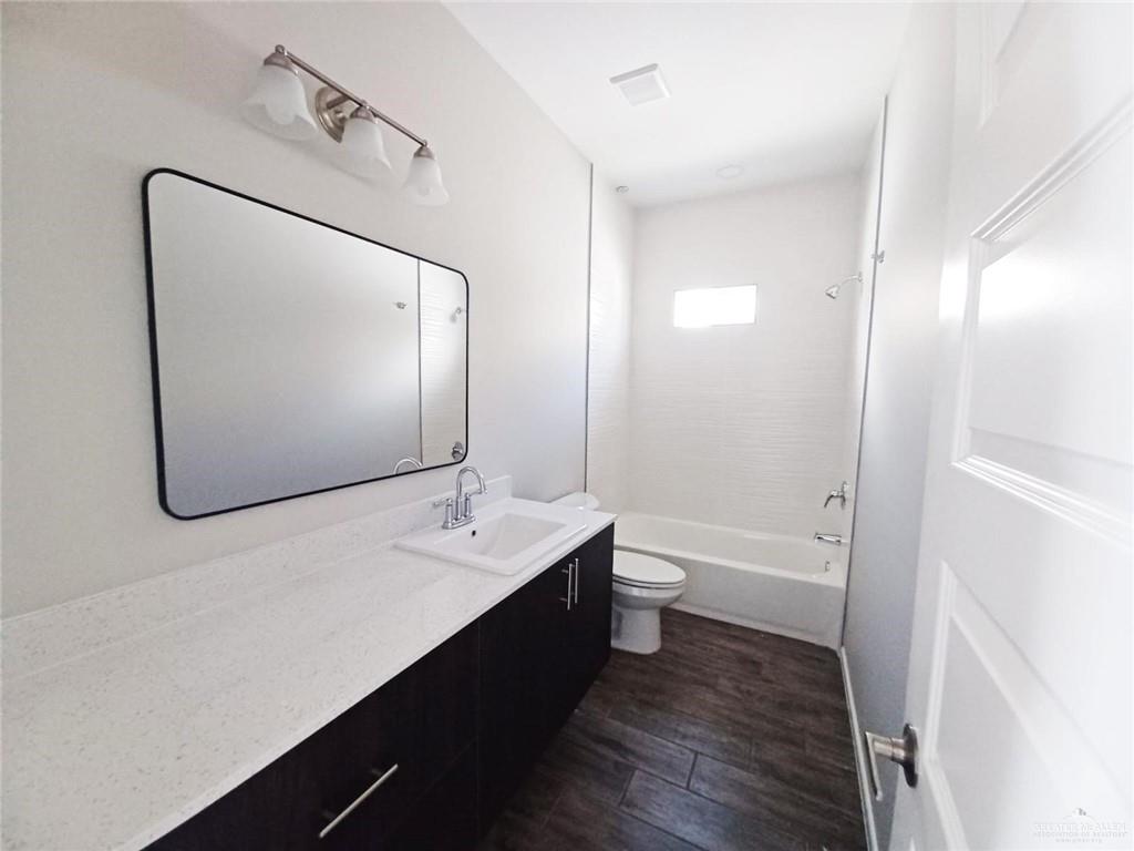 907 East Starr Road, Unit D Mercedes, TX 78570 - Photo 10 of 10 a bathroom with a double vanity sink toilet mirror and bathtub