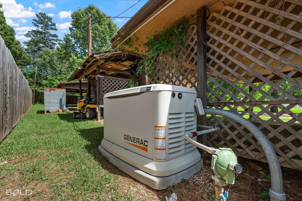 225 Marie Road Ringgold, LA 71068 - Photo 12 of 40 Generac whole-home generator with exposed piping, positioned on a gravel base