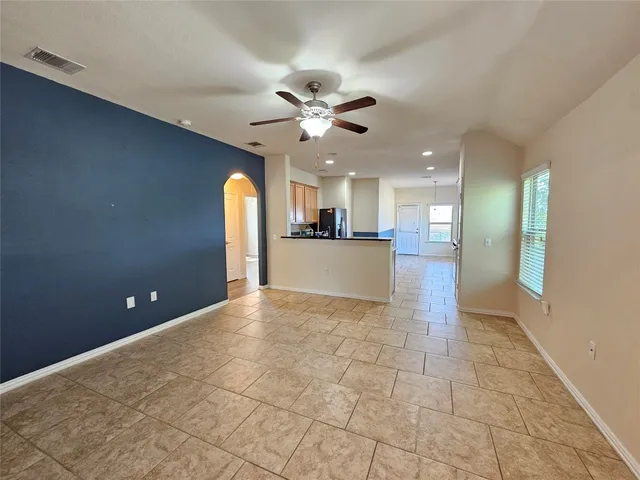 a kitchen with stainless steel appliances granite countertop a stove top oven a sink dishwasher a dining table and chairs with wooden floor