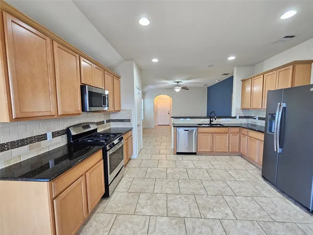 a kitchen with granite countertop a stove top oven and cabinets