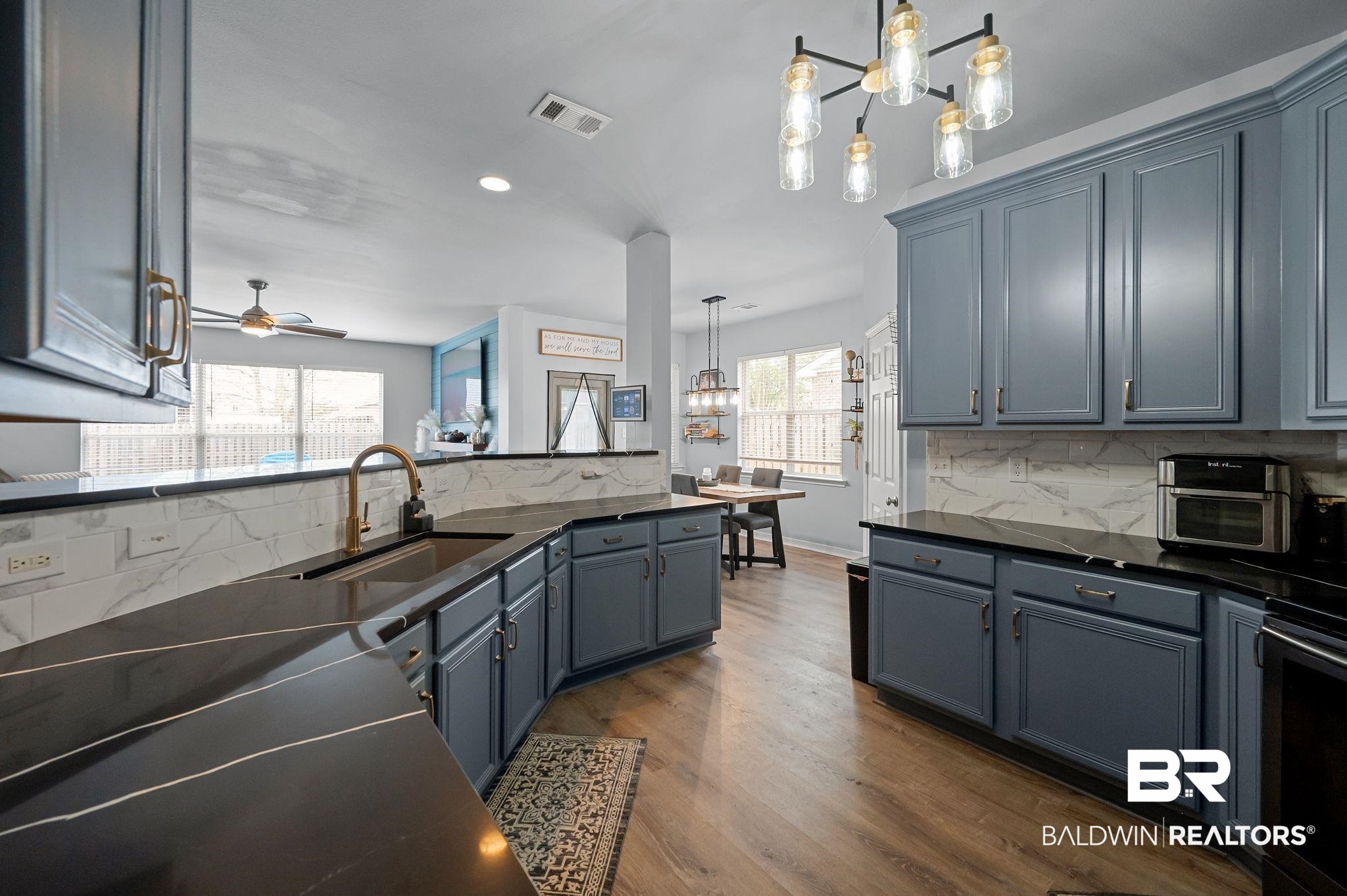 1287 Pembroke Way Foley, AL 36535 - Photo 16 of 39 Kitchen with hanging lights, wood finished floors, dark stone counters, and a ceiling fan