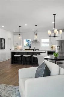 a kitchen with a stove a kitchen island a sink and white cabinets