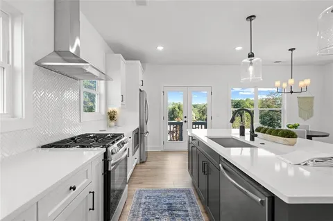 a kitchen with stainless steel appliances a sink stove and cabinets