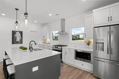 a kitchen with a sink stainless steel appliances and white cabinets