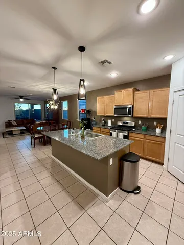 a kitchen with stainless steel appliances granite countertop a sink and a refrigerator