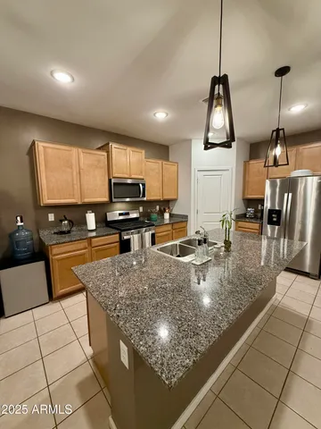 a kitchen with stainless steel appliances granite countertop a sink a stove counter space and cabinets