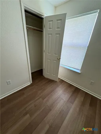 an empty room with wooden floor and closet