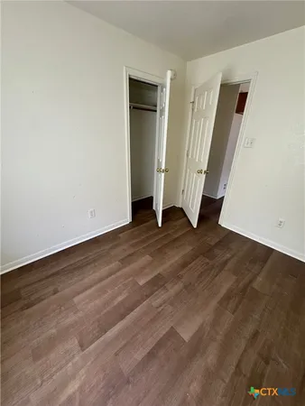 an empty room with wooden floor and closet