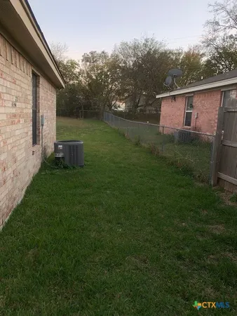 a view of a backyard with plants and a barbeque