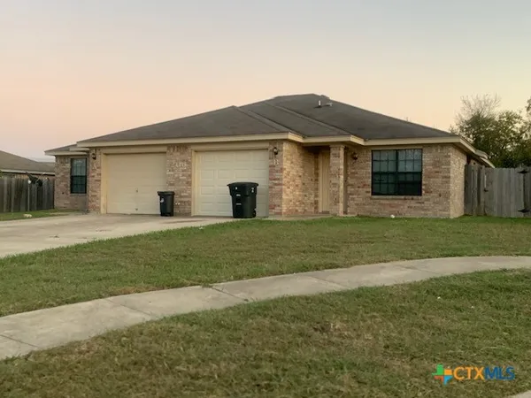 a view of a yard in front of a house with large trees
