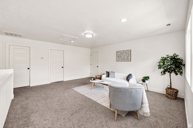 1552 Sumac Drive Logan, UT 84321 - Photo 33 of 72 Spacious carpeted room featuring white walls, multiple paneled doors with black hardware, and recessed lighting