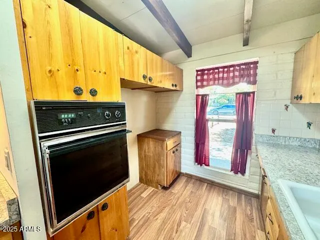 a view of a kitchen with stainless steel appliances wooden floor and a window
