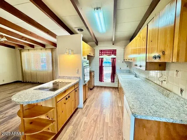 a kitchen with stainless steel appliances granite countertop a sink and wooden cabinets with a granite countertops