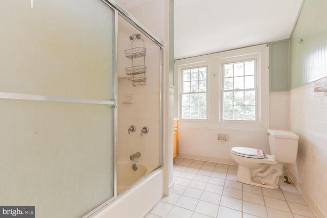 5865 Solomons Island Road Tracys Landing, MD 20779 - Photo 19 of 29 a bathroom with a granite countertop toilet a sink and a bathtub